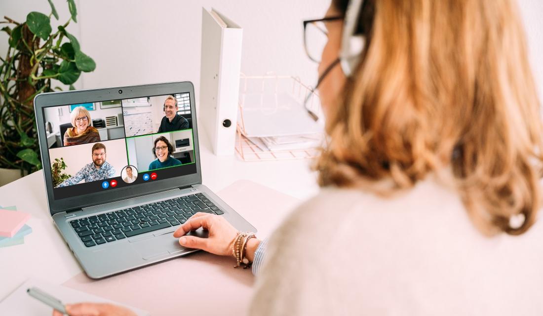 Frau am Laptop chattet mit vier anderen Personen.