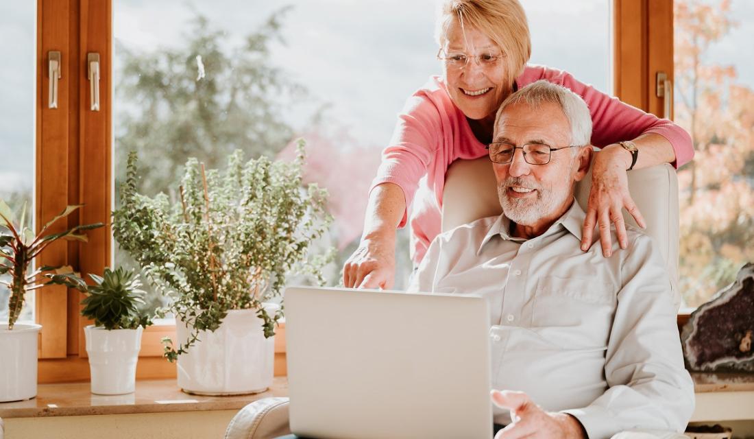 Paar schaut gemeinsam in einen Laptop.
