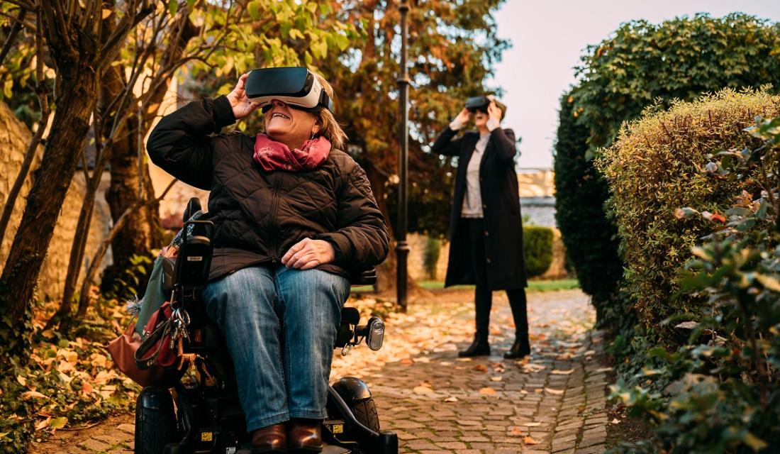 Eine Frau im Rollstuhl mit einer virtual realty Brille auf.