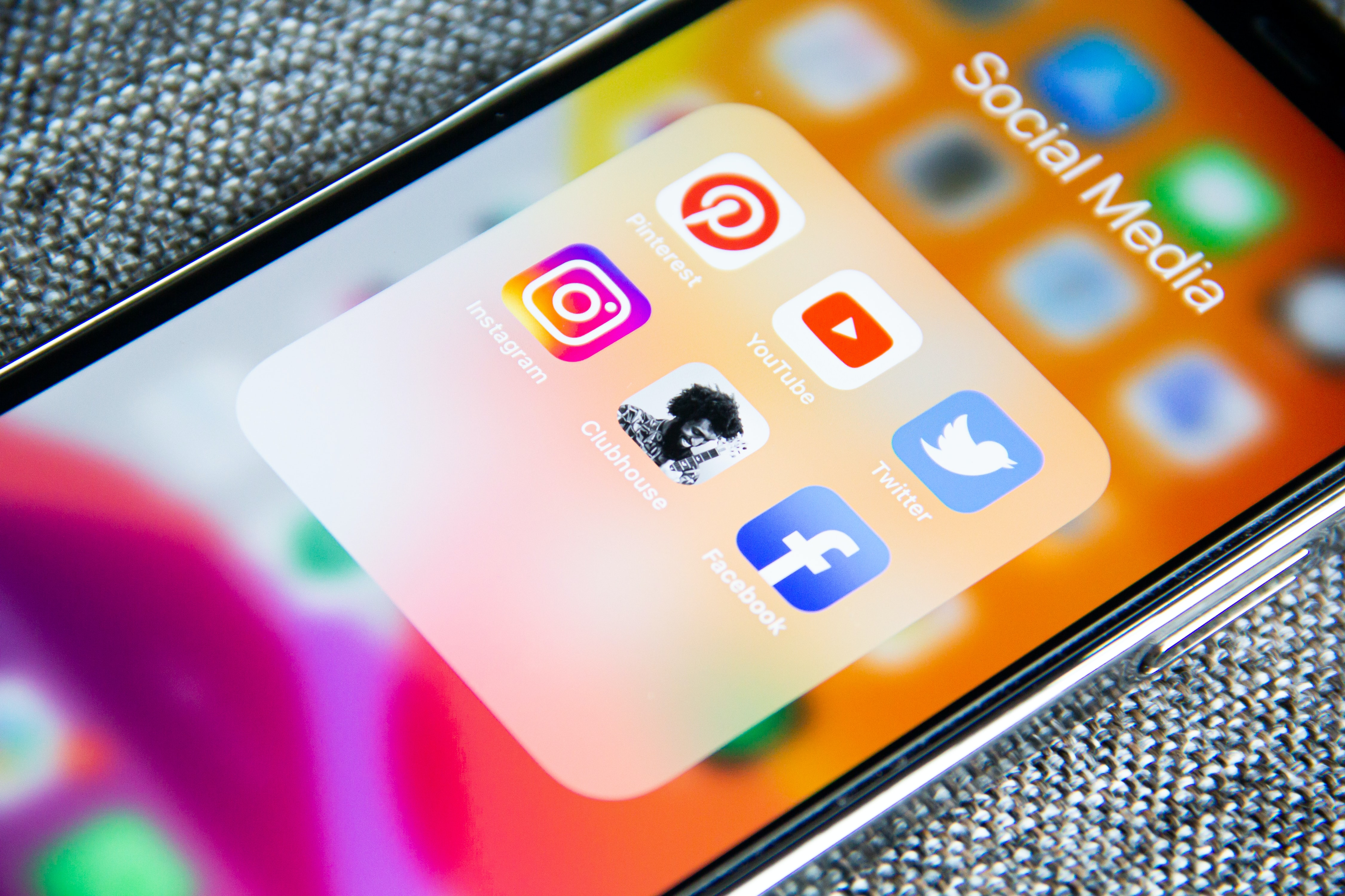 Auf einem bunten Handybildschirm sind verschiedene Apps aus der Kategorie Soziale Netzwerke zu sehen wie Twitter und Facebook.