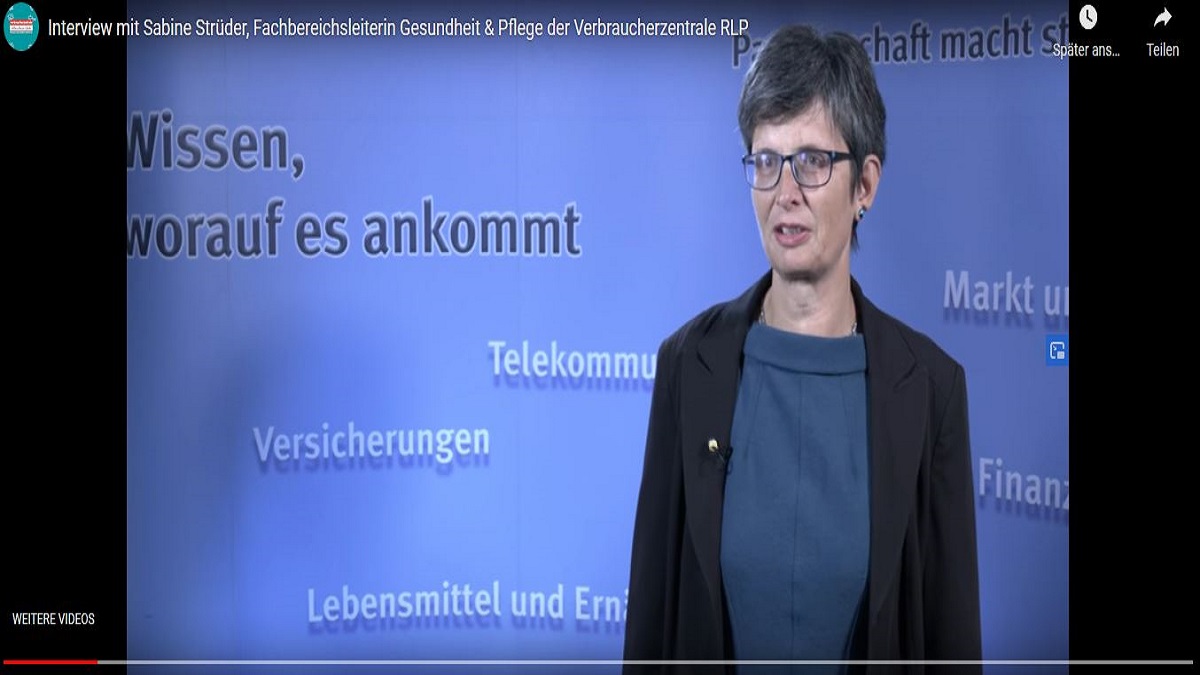 Videoausschnitt: Eine Frau vor einer blauen Wand.