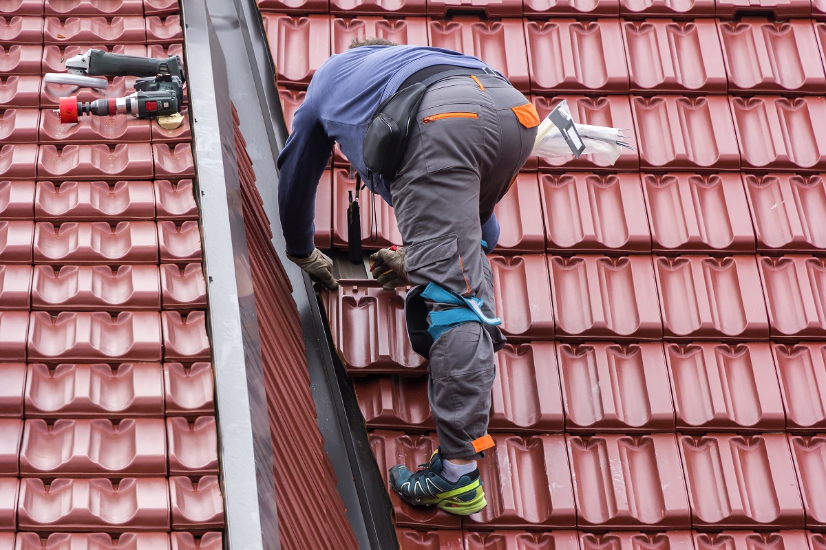 Ein Handwerker repariert ein Dach.
