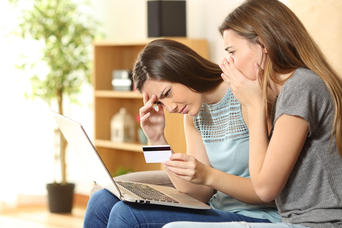 Frauen am Laptop sitzend schauen schockiert aufs Display