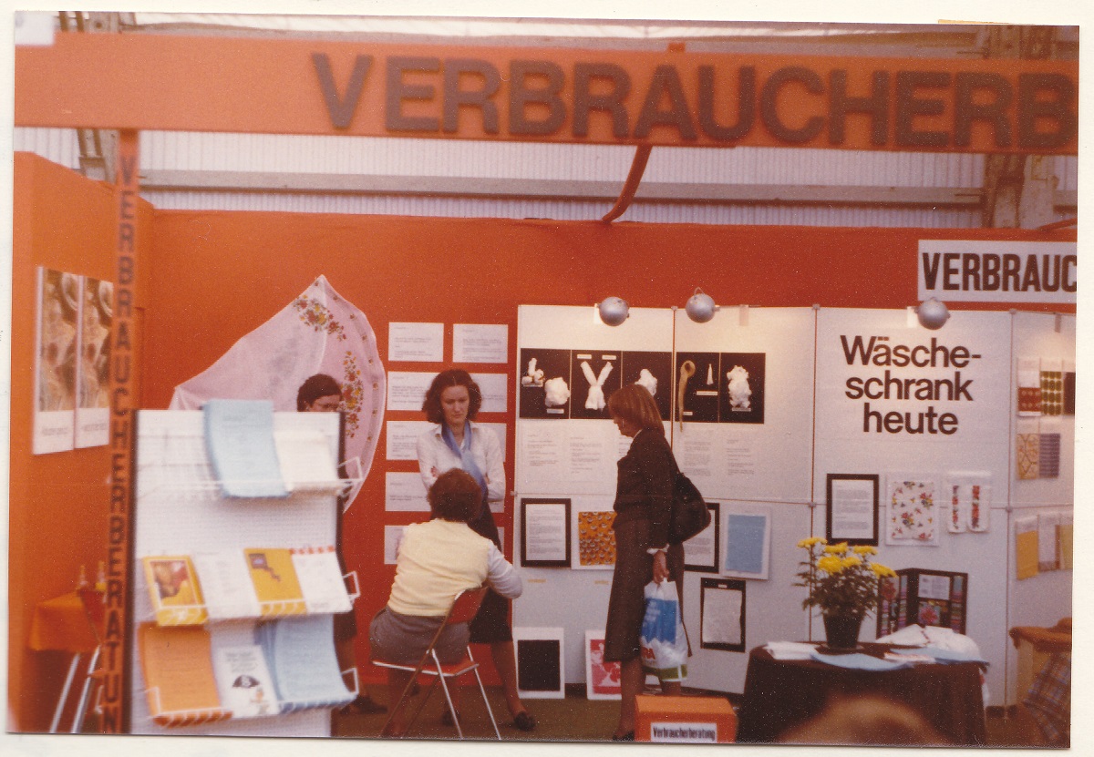 Personen an einem Messestand.