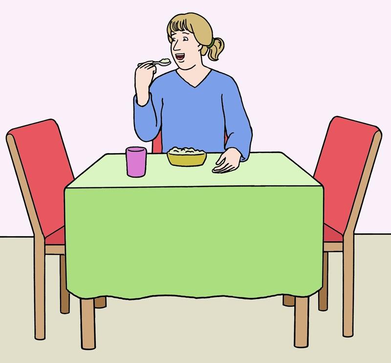 Frau isst am Tisch 