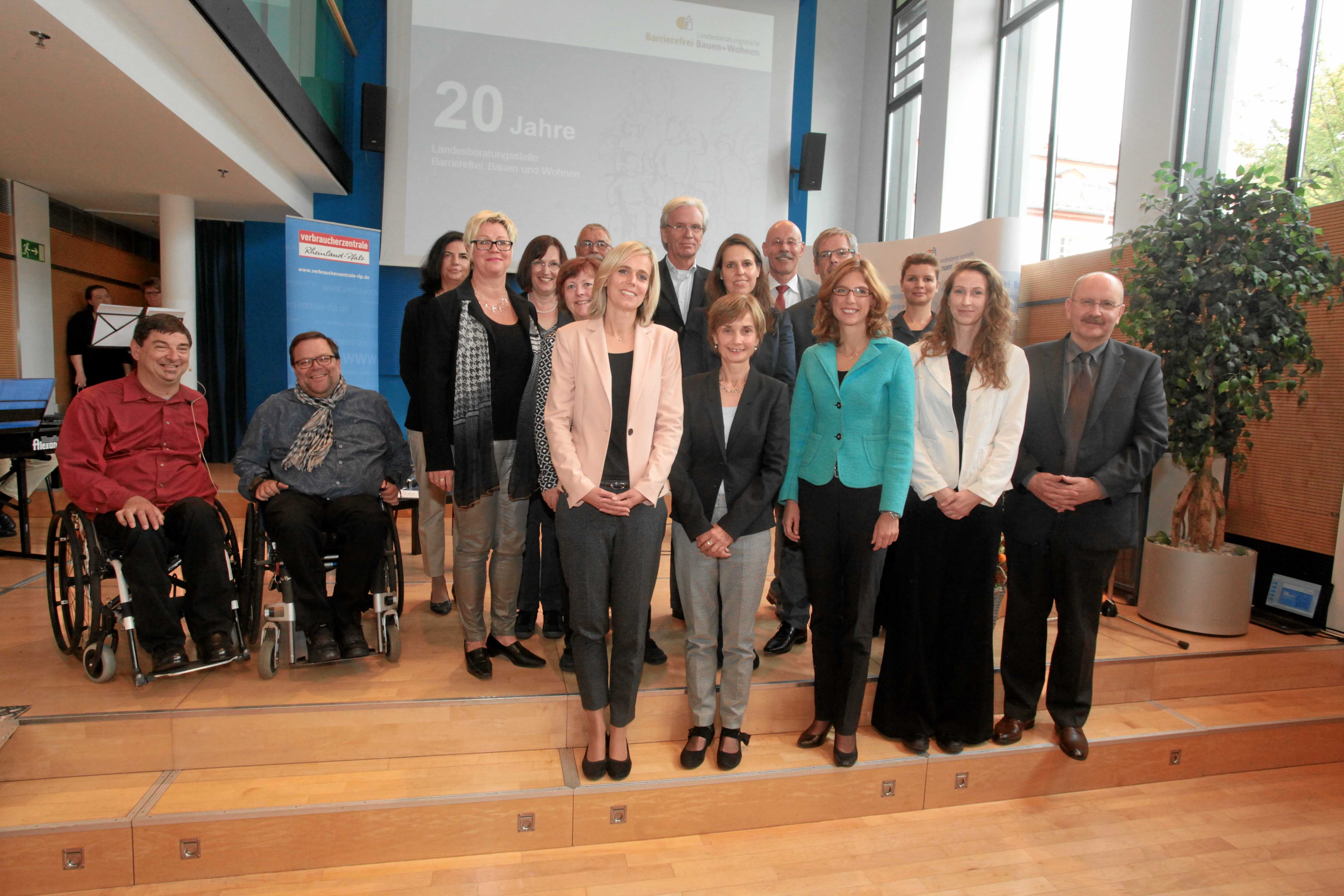 Menschens tehen auf der Bühne für ein Gruppenbild.