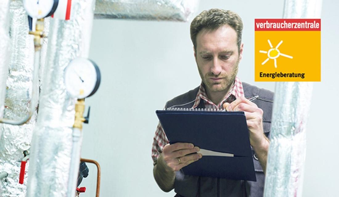 Energieberater macht sich Notizen im Heizungskeller