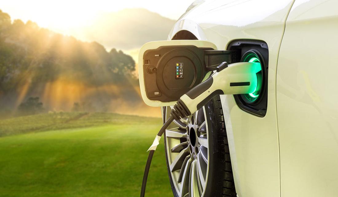 Das E-Auto wird mit einem Ladekabel aufgeladen.