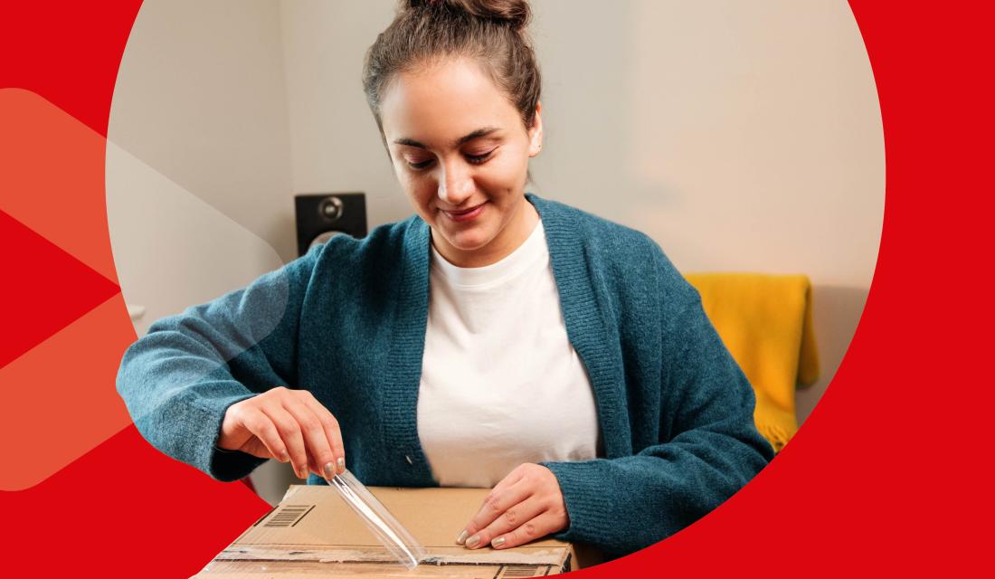 junge Frau packt Paket aus