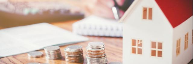 Modellhaus und Geld auf einem Tisch.