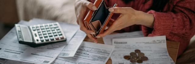 Hände mit Geldbörse und Taschenrechner von Rechnungen