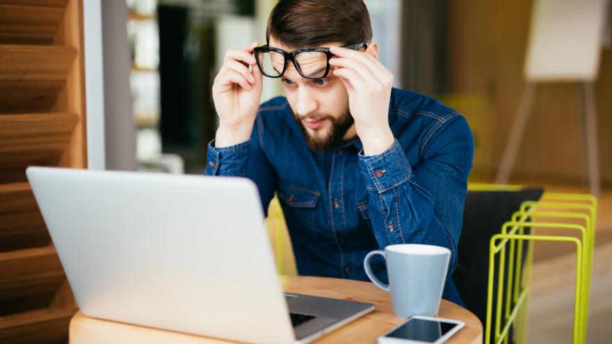 Mann sitzt vor dem Laptop