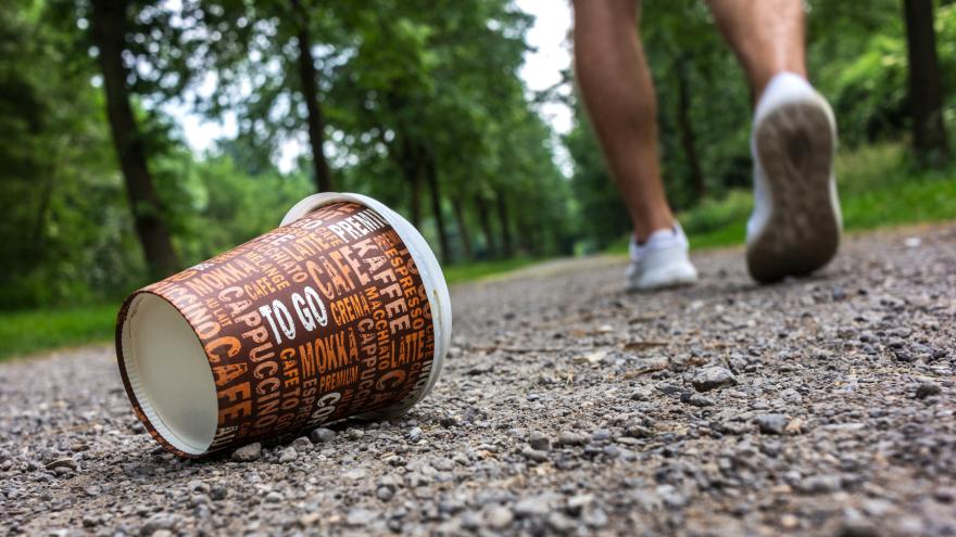 Ein weggeworfener To-go-Becher liegt auf dem Weg