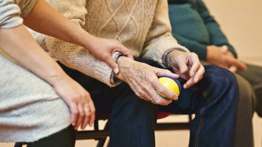 älterer Mensch hält einen Ball