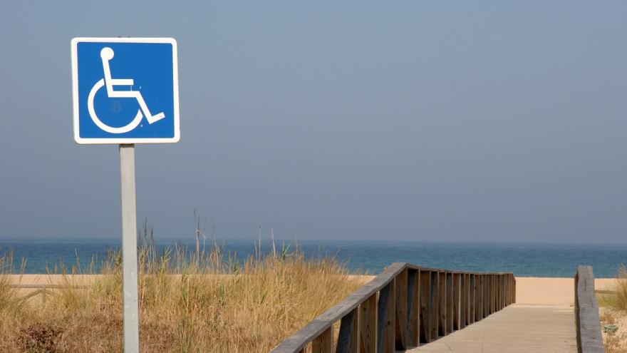 Schild mit Rollstuhl am Strand.