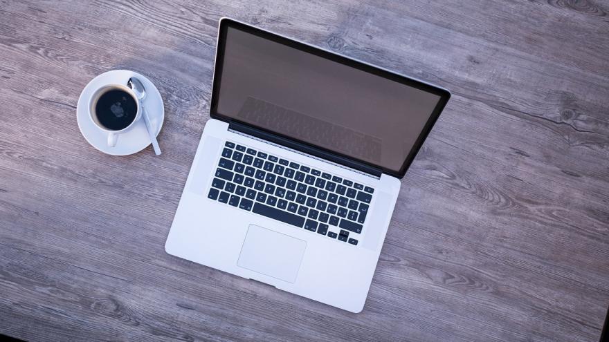 Laptop und Kaffeetasse auf einem Schreibtisch.