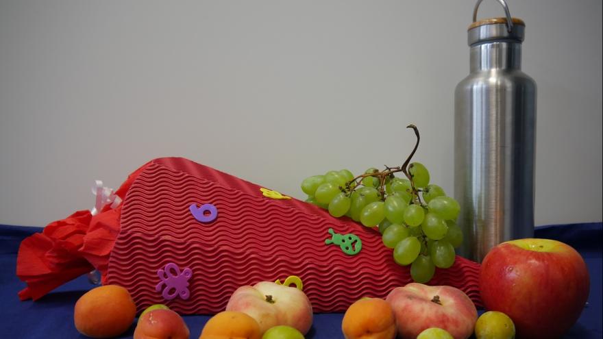 Schultüte mit Obst und einer Alu-Getränkeflasche.