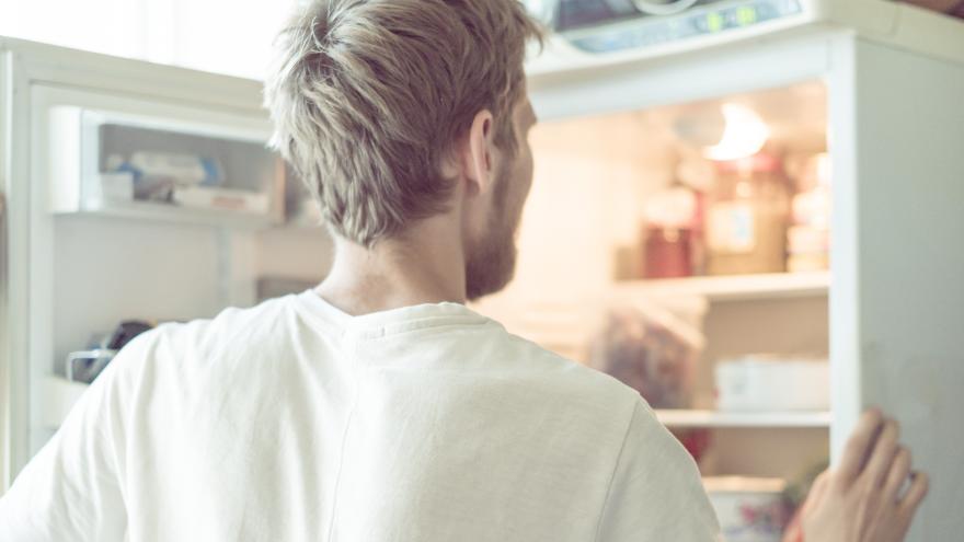 Ein Mann schaut in seinen Kühlschrank