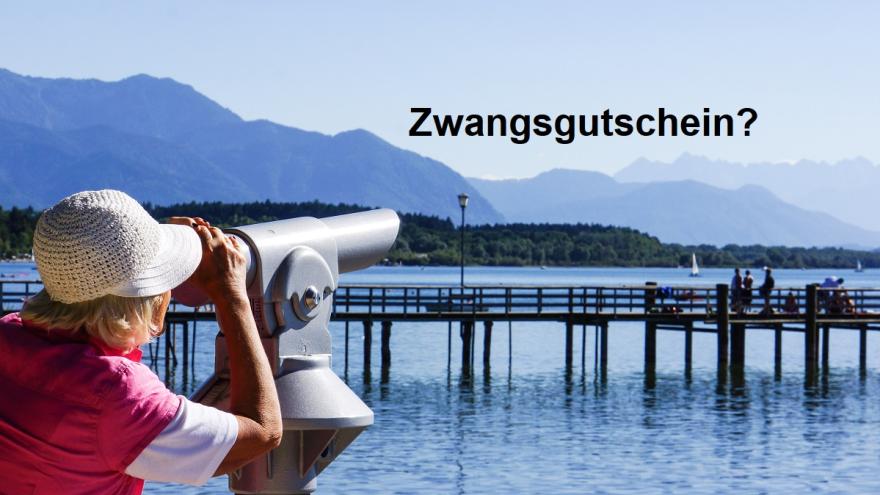 Frau schaut durch ein Fernrohr auf einen See udn imHinetrgrund steht: Zwangsgutschein?