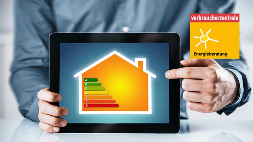 Ein Mann, dessen Torso zu sehen ist, zeigt ein Tablet in die Kamera, auf dem ein gelbes Haus zu sehen ist. Im Bild des Hauses sind die verschiedenen Energieeffizientstufen zu sehen.