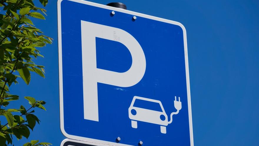 Ein blaues Parkplatzschild mit dem Symbol eines E-Autos. 