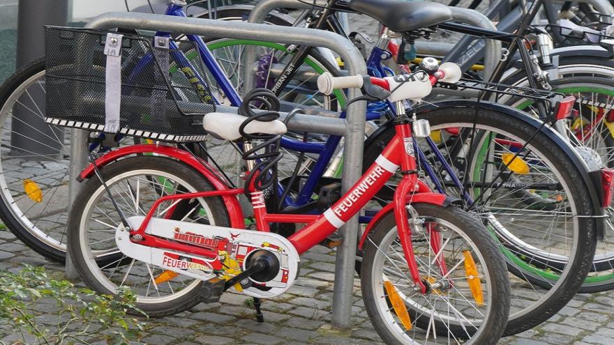 Viele Fahrräder angeschlossen an Fahrradständern.