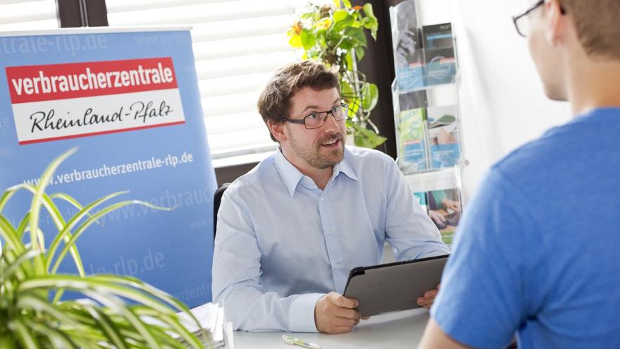 Zwei Personen an einem Schreibtisch im Gepräch.
