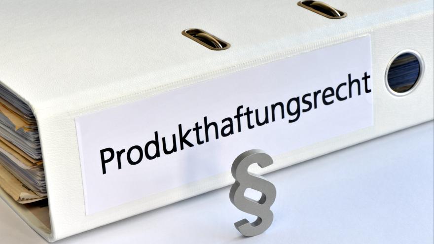 Ein Aktenordner mit der Aufschrift Produkthaftungsrecht liegt auf einem Tisch