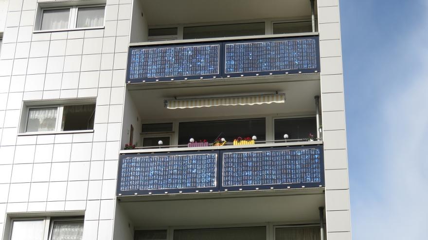 Hochhaus mit Solarpanelen an den Balkonen. 