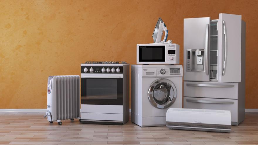 Mehrere Elektrogeräte, darunter ein Kühlschrank, eine Mikrowelle, ein Bügeleisen