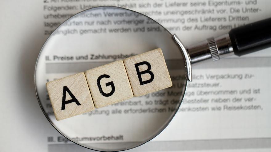 Eine Lupe vergrößert das gescrabbelte Wort AGB