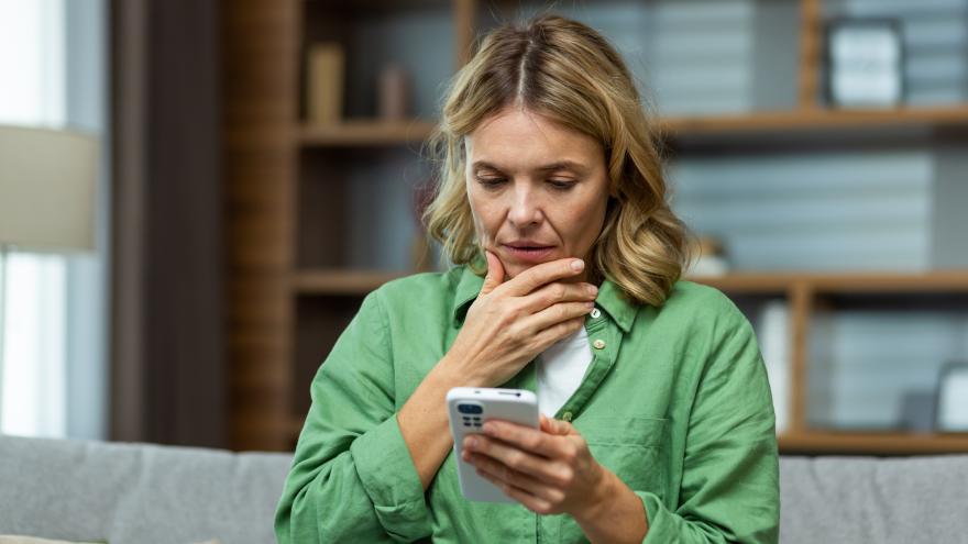 Frau schaut besorgt auf Smartphone