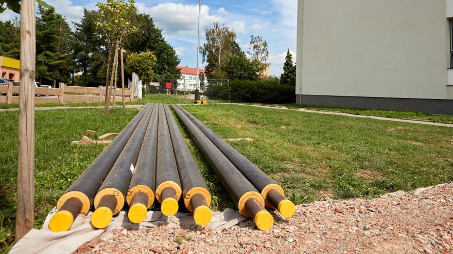 Heizungsrohre liegen vor einem Haus und müssen verlegtwerden.