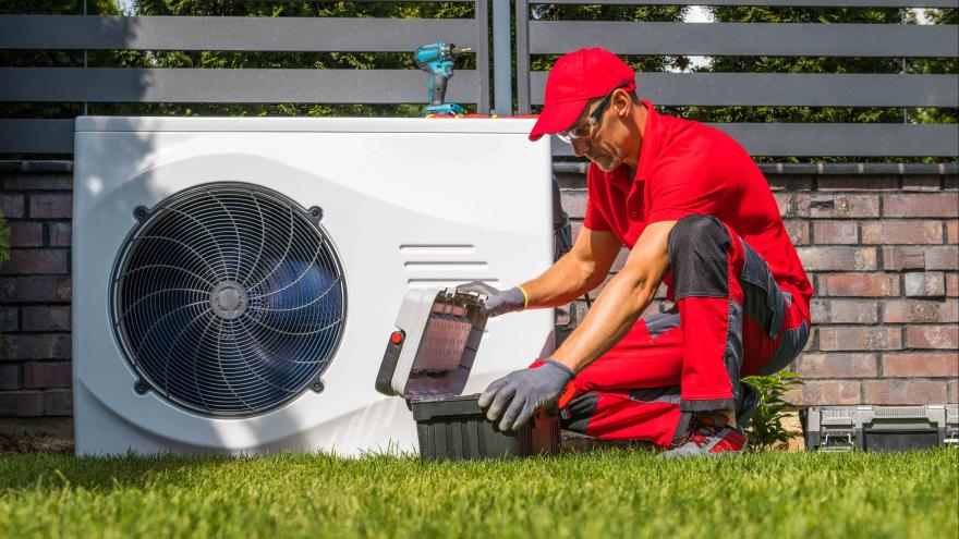 Mann arbeitet an Wärmepumpe
