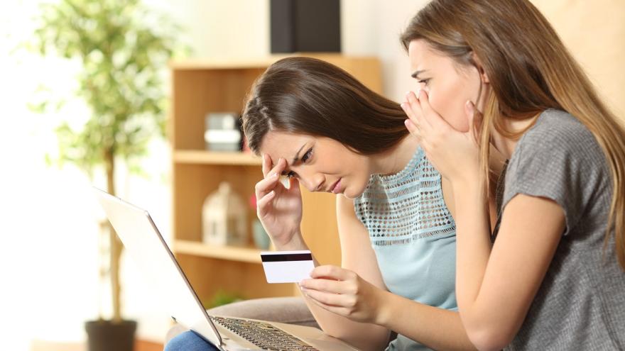 Zwei junge Frauen am Laptop schauen geschockt.
