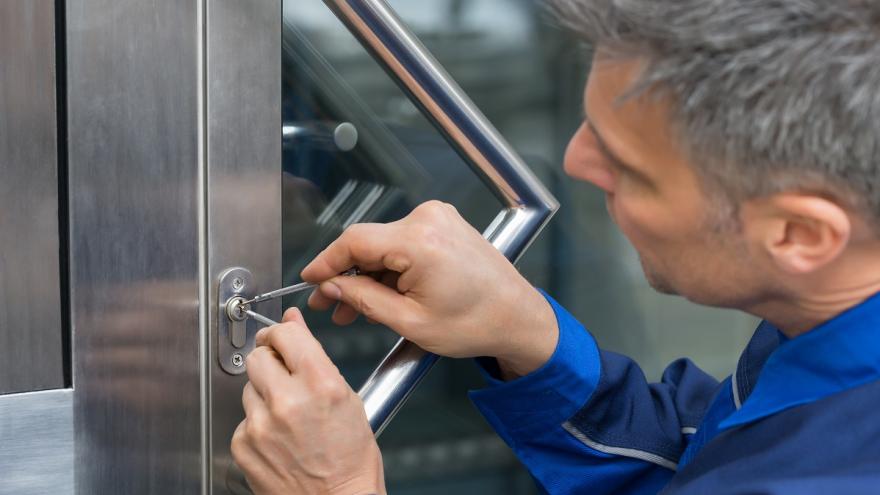 Ein HAndwerker versucht eine Tür zu öffnen.