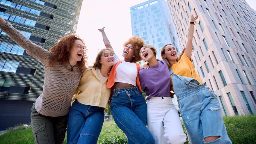 Fünf junge Frauen Arm in Arm.