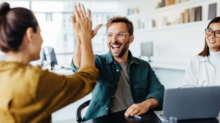 Ein Team gratuliert sich zum Erfolg im Büro.