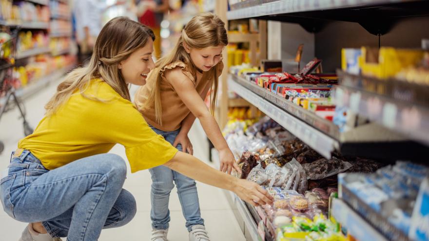 Frau mit Kind am Supermarktregal