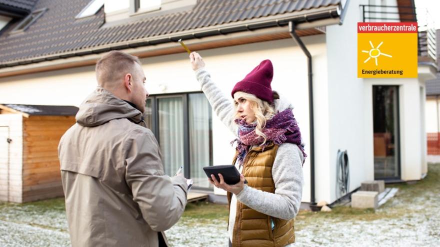 Energieberaterin berät Verbraucher vor seinem Haus