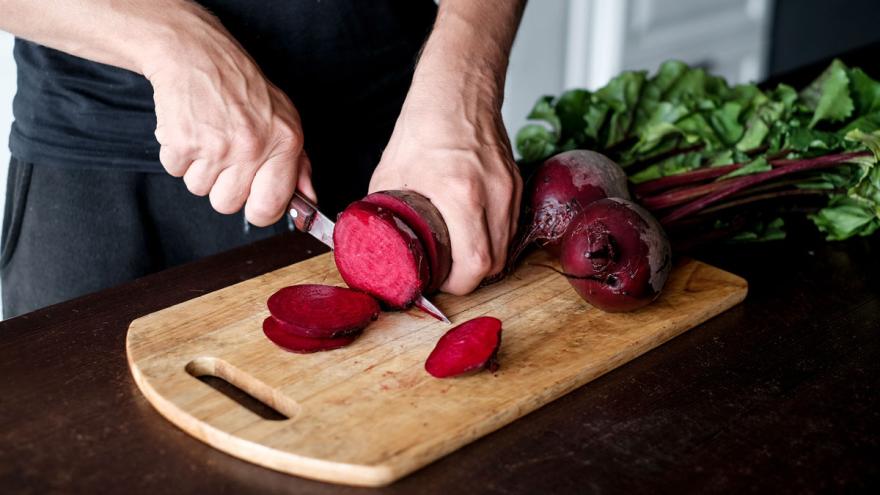 Frau schneidet rote Beete