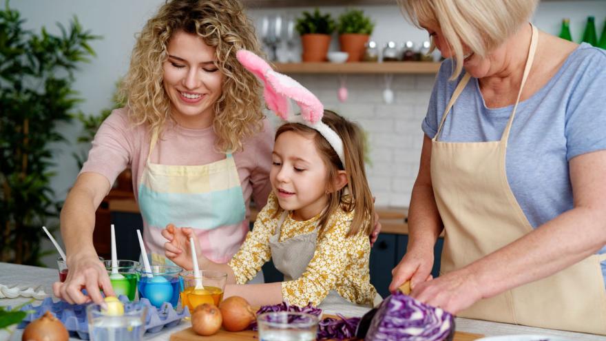 Mutter, Oma und Tochter färben Ostereier.