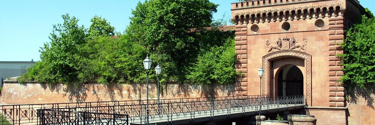 Ein Stadttor mit Brücke aus Stein.