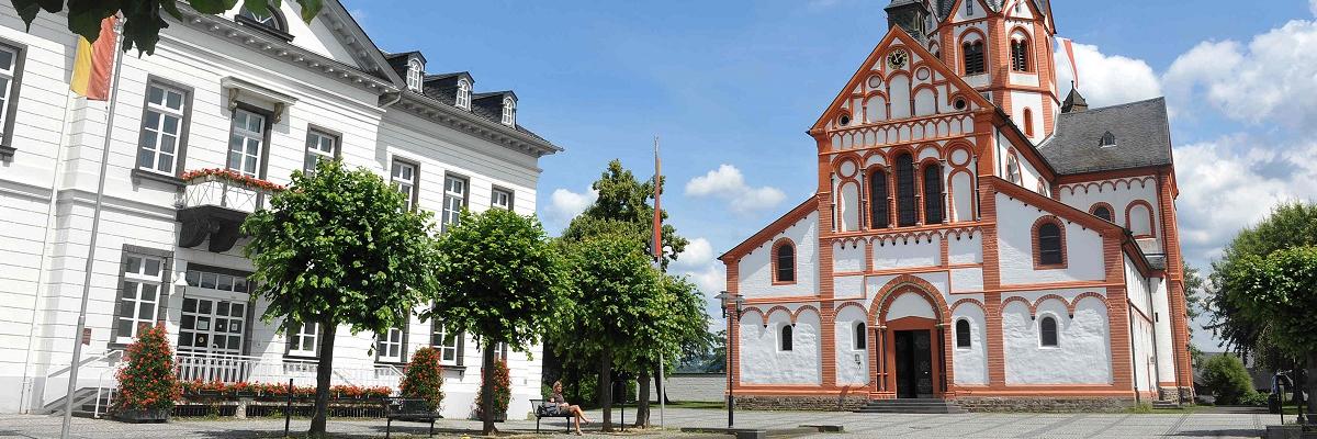 Ein großer Platz mit einem Haus mit Turmspitze.