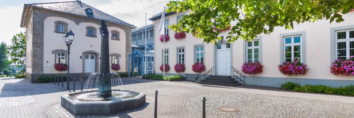 Ein großer Platz mit Häusern udn einem Brunnen in der Mitte.