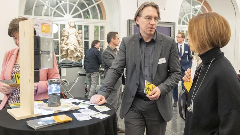 Frau und Mann im Gespräch an einem Infostand.