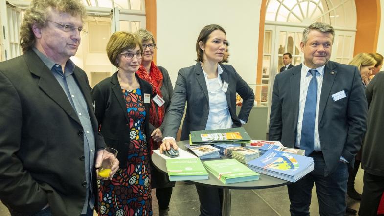 Personen stehen vor einem Infostand. 