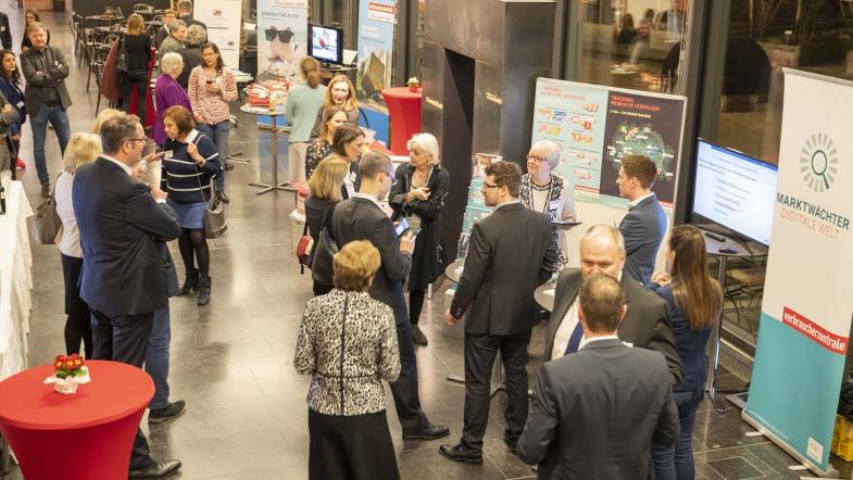 Menschen in einem Foyer.