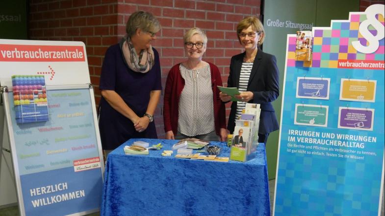 Drei Personen an Info-Stand.