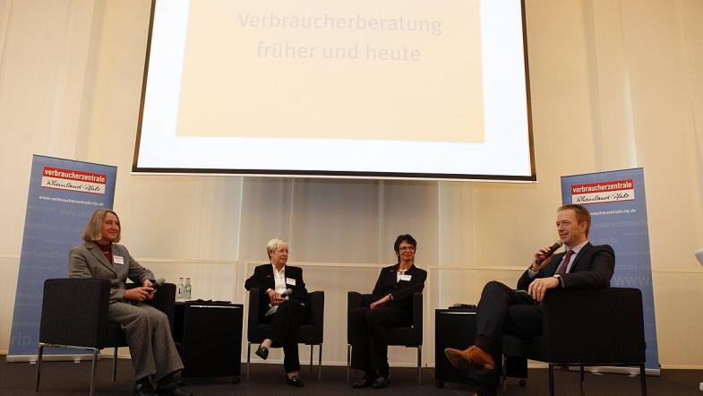 Vier Menschen diskutieren auf einer Bühne über ein Thema.